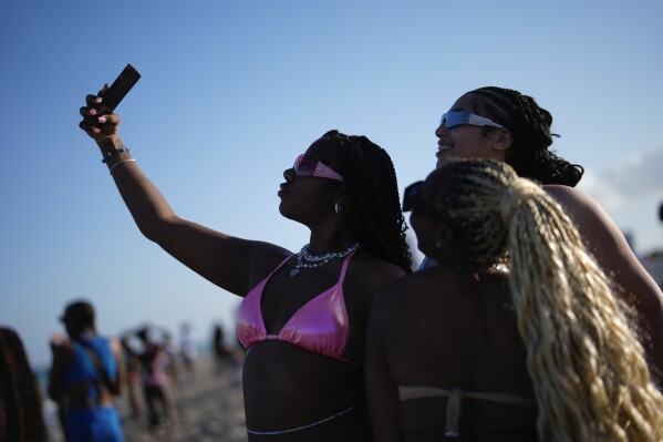 Women pose for a selfie on South Beach during spring break, March 15, 2024, in Miami Beach, Fla. (AP Photo/Rebecca Blackwell, File)