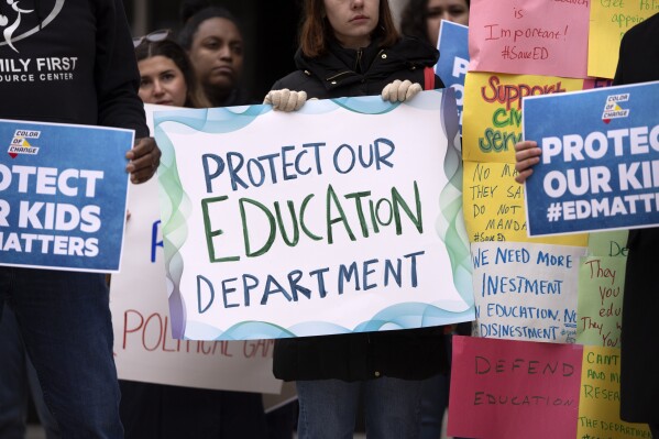 Protestors gather during a demonstration at the headquarters of the Department of Education, Friday, March 14, 2025, in Washington. (AP Photo/Mark Schiefelbein)