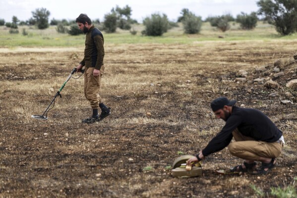 Members of the Ministry of Defence clear landmines left behind by the Syrian army during the war, in agricultural land south of Idlib, Syria, Sunday, April 13, 2025. (AP Photo/Ghaith Alsayed)