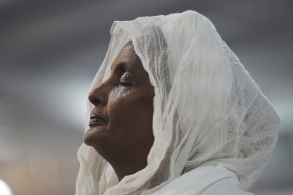 A congregant of the Re'ese Adbarat Debre Selam Kidist Mariam Church, an Ethiopian Orthodox Tewahedo church, stands during a service in Washington, D.C., Saturday, April 5, 2025. (AP Photo/Jessie Wardarski)