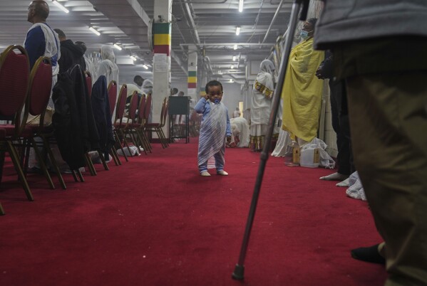 A young child wears a netela, the white scarf-like cotton cloth worn by worshippers, during a service at Re'ese Adbarat Debre Selam Kidist Mariam Church, an Ethiopian Orthodox Tewahedo church, in Washington, D.C., Saturday, April 5, 2025. (AP Photo/Jessie Wardarski)