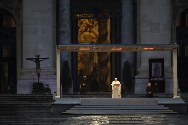 Pope Francis, standing alone at center, delivers an Urbi et orbi prayer from the empty St. Peter's Square, at the Vatican, Friday, March 27, 2020. Praying in a desolately empty St. Peter's Square, Pope Francis on Friday likened the coronavirus pandemic to a storm laying bare illusions that people can be self-sufficient and instead finds