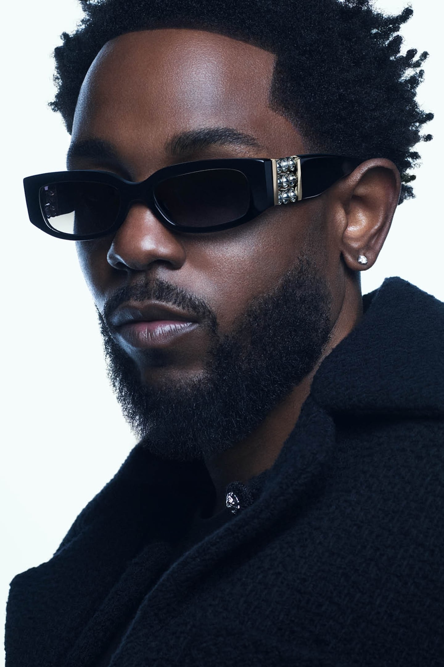 Close Kendrick Lamar headshot in black coat and black Chanel sunglasses.