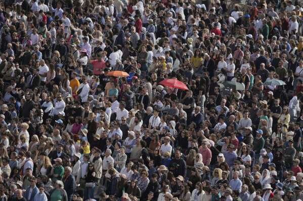 People gather in St. Peter's Square as they await the arrival of the body of Pope Francis, who will lie in state at St. Peter's Basilica for three days, at the Vatican, Wednesday, April 23, 2025. (AP Photo/Markus Schreiber)
