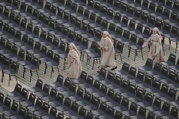 Nuns arrive to St. Peter's Square as they await the arrival of the body of Pope Francis, who will lie in state at St. Peter¥s Basilica for three days, at the Vatican, Wednesday, April 23, 2025. (AP Photo/Markus Schreiber)