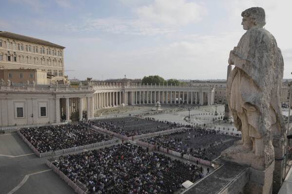 People gather in St. Peter's Square as they await the arrival of the body of Pope Francis, who will lie in state at St. Peter's Basilica for three days, at the Vatican, Wednesday, April 23, 2025. (AP Photo/Markus Schreiber)