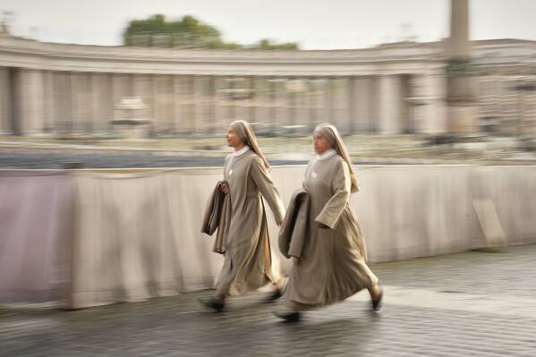 Nuns arrive in St. Peter's Square as they await the arrival of the body of Pope Francis, who will lie in state at St. Peter's Basilica for three days, at the Vatican, Wednesday, April 23, 2025. (AP Photo/Andreea Alexandru)