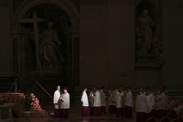 Priests in St. Peter's Basilica wait for the arrival of the body of Pope Francis, who will lie in state for three days, at the Vatican, Wednesday, April 23, 2025. (AP Photo/Francisco Seco)