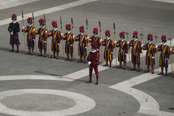 Swiss guards stand in St. Peter's Square as they await the arrival of the body of Pope Francis, who will lie in state at St. Peter's Basilica for three days, at the Vatican, Wednesday, April 23, 2025. (AP Photo/Markus Schreiber)