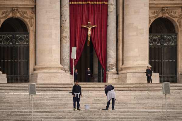 Men wash the steps St. Peter's Basilica before the arrival of the body of Pope Francis, who will lie in state at for three days, at the Vatican, Wednesday, April 23, 2025. (AP Photo/Andreea Alexandru)