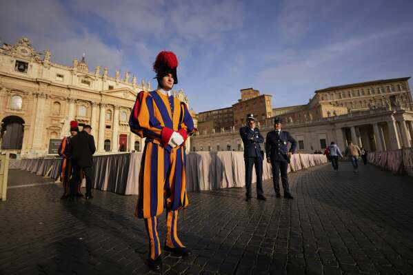 Pontifical Swiss guards stand in St. Peter's Square before the arrival of the body of Pope Francis, who will lie in state at St. Peter's Basilica for three days, at the Vatican, Wednesday, April 23, 2025. (AP Photo/Andreea Alexandru)