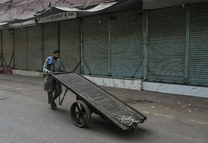 A labourer pushing a handcart walks through a deserted street during a nationwide strike to show their solidarity with Palestinians, in Karachi on April 26, 2025, amid the ongoing Gaza conflict. Photo: AFP