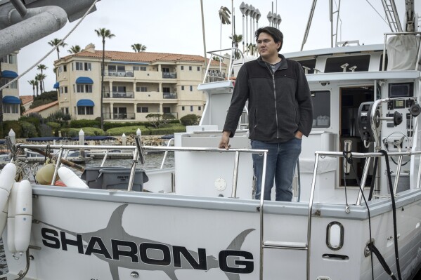 Blake Hermann, a fourth-generation commercial fisherman, poses for a portrait aboard his boat in Oxnard, Calif., Thursday, May 1, 2025. (AP Photo/Annika Hammerschlag)