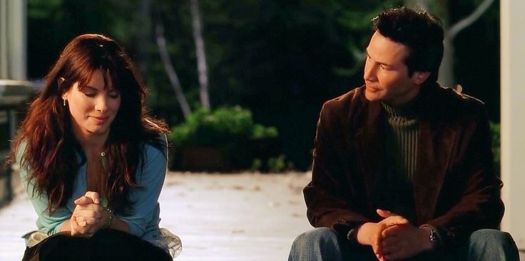 This may contain: a man sitting next to a woman on the ground