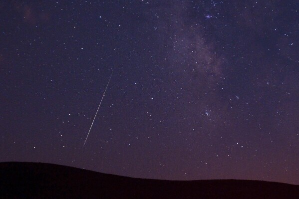 A Perseid meteor streaks across the sky during the Perseid meteor shower in Vinton, California, Aug. 11, 2009. (AP Photo/Kevin Clifford, File)