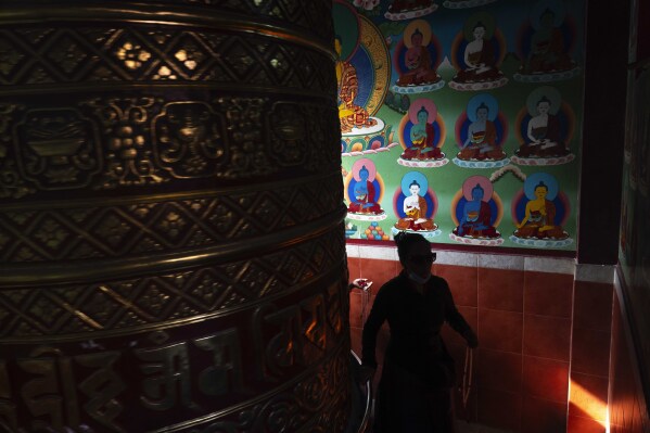 A devotee spins a prayers wheel during Buddha Jayanti, also known as Buddha Purnima festival, to celebrate Buddha's birthday, in Boudhanath Stupa, Kathmandu, Nepal, Monday, May 12, 2025. (AP Photo/Niranjan Shrestha)
