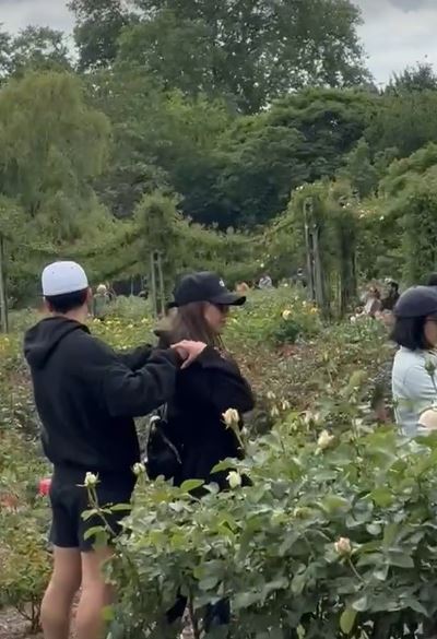 Jessica Alba kissing a man in a garden.