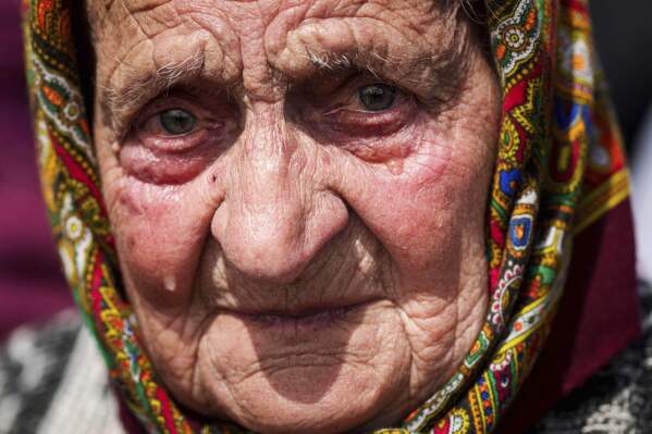 A woman cries during a funeral ceremony for Tamara Martyniuk, 8, Stanislav Martyniuk, 12, and Roman Martyniuk, 17, killed in a Russian strike on Sunday, in Korostyshiv, Zhytomyr region, Ukraine, Wednesday, May 28, 2025. (AP Photo/Evgeniy Maloletka)