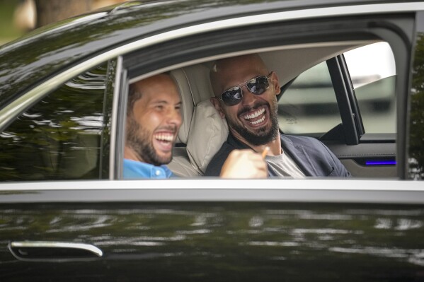 Andrew Tate, right, and his brother Tristan laugh as they leave the Bucharest Tribunal in Bucharest, Romania, May 8, 2024. (AP Photo/Vadim Ghirda, File)