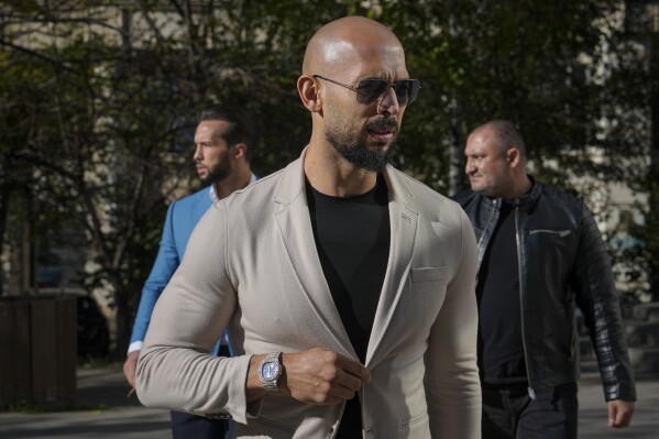 Andrew Tate, center, and his brother Tristan, left, arrive at the Bucharest Tribunal in Bucharest, Romania, Nov. 16, 2023. (AP Photo/Vadim Ghirda, File)
