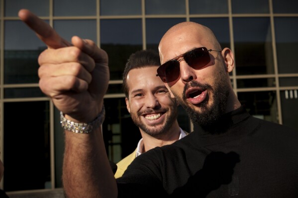 Andrew Tate gestures, next to his brother Tristan, outside the Bucharest Tribunal in Bucharest, Romania, Thursday, Jan. 9, 2025. (AP Photo/Vadim Ghirda, File)